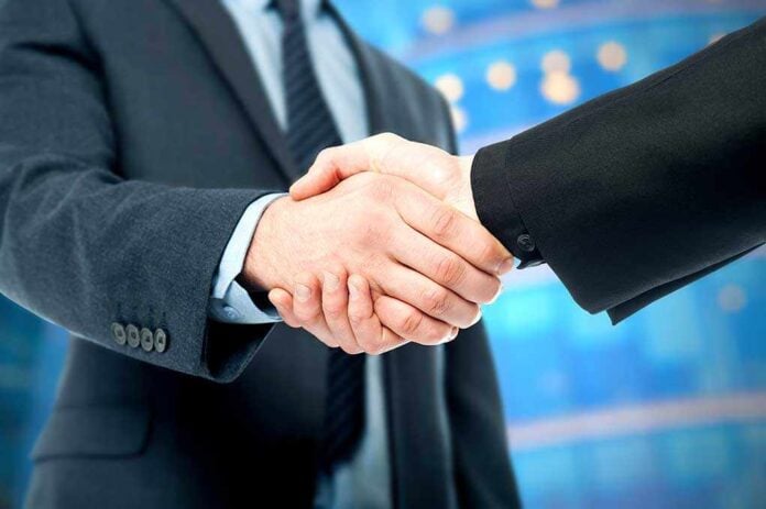 Two business professionals shaking hands in a corporate setting