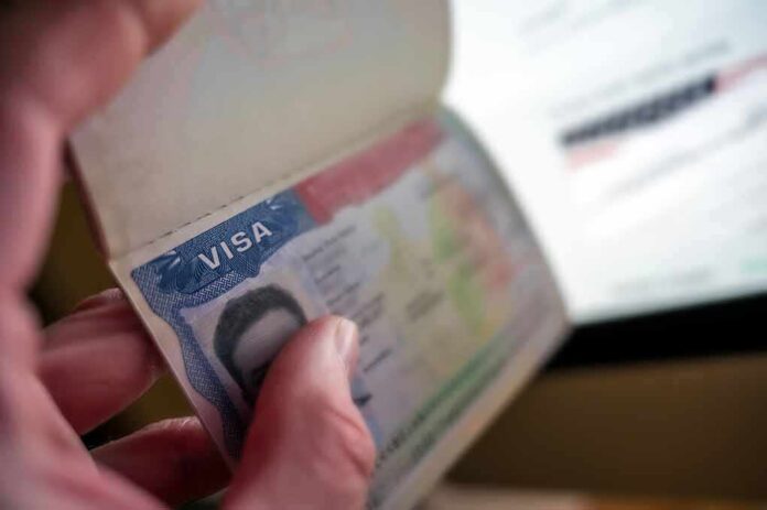 A hand holding a passport open to a visa page