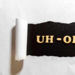 Torn paper revealing UH-OH text underneath.