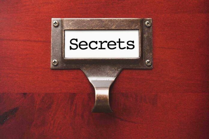 A label holder on a wooden surface with the word Secrets displayed