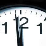 Close-up of a clock showing the time just before noon