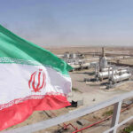 Iranian flag near an industrial gas refinery.
