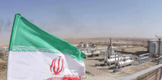 Iranian flag near an industrial gas refinery.