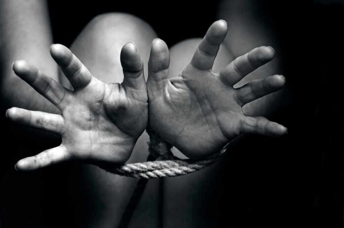 Two hands reaching out, bound by rope in a black and white image