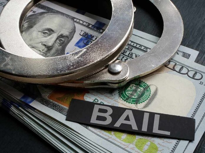 Handcuffs resting on a stack of cash with a 'BAIL' label