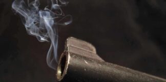 Vigilante Justice Twist Shocks Memphis Murder Close-up of a gun barrel emitting smoke against a black background