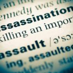 Close-up of a dictionary page showing the definition of 'assassination'