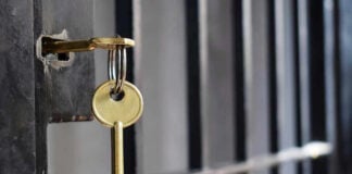 Key in lock of prison cell door.