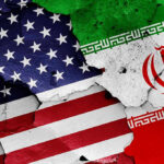 Cracked American and Iranian flags painted on a wall.