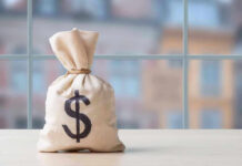 Money bag with dollar sign on table.