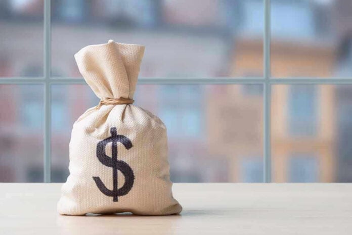 Money bag with dollar sign on table.