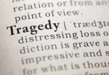 Close-up of the word 'Tragedy' in a dictionary with its definition