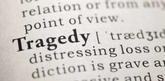 Close-up of the word 'Tragedy' in a dictionary with its definition