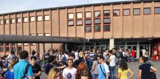 A large group of students socializing outside a school building