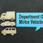 Wooden cutouts of various vehicles with a speech bubble stating Department Of Motor Vehicles