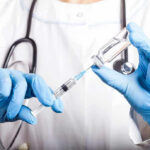 SHOCKING Nasal Spray Claim: Brain Aging Reversed? Doctor filling syringe with vaccine from vial.