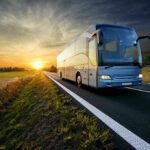 Caltrans’ Daring Pitch: 140 MPH Freeway Buses! Bus driving on a road at sunset.