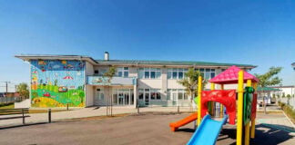 Colorful playground slide in front of a building.