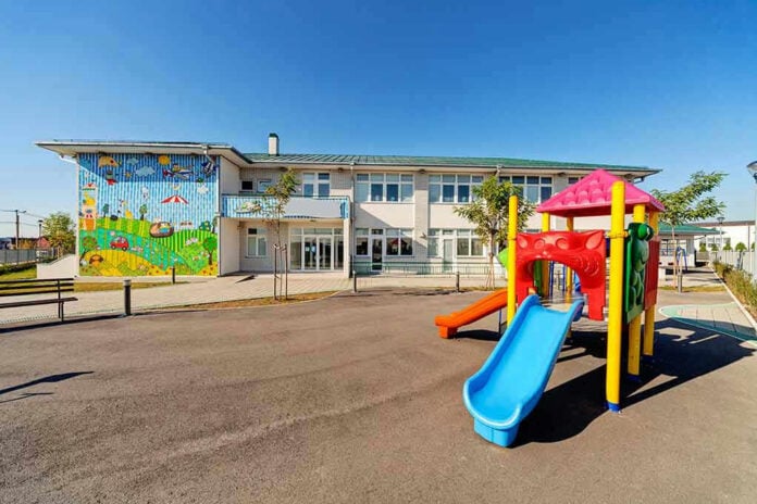 20485255 Colorful playground slide in front of a building.