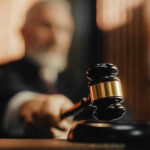 Judge using gavel in a courtroom setting.