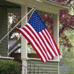 Man Kicks American Flags on Memorial Day — Caught on Camera American flag hanging from a porch.