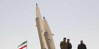 Iran’s THREAT — Gulf on HIGH ALERT! Military personnel beside missiles and Iranian flag.