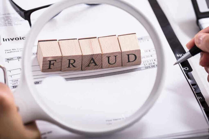 Fraud blocks under magnifying glass on invoices.