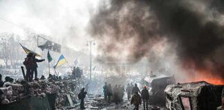 Hypersonic Missiles Pound Kyiv – What’s Next? A chaotic protest scene with smoke, fire, and people holding flags