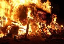 A large fire engulfing debris at night