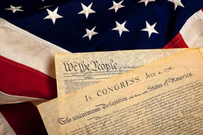 United,States',Constitution,And,Declaration,Of,Independence,On,A,Flag The Declaration of Independence laid on an American flag
