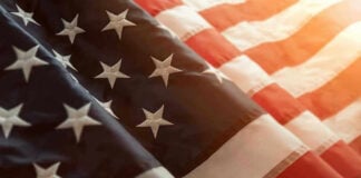 Media Spin: A Simple Flag Video Became a Culture War Overnight Close-up of American flag with sunlit background.