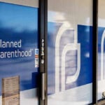Down Syndrome Abortion Rates Spark Debate Planned Parenthood office entrance with logo and signs.