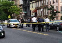 No Arrests Made on Harlem Scooter Crash Police gathered at an urban crime scene.