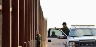 Appeals Shock: Court Restores Key Immigration Enforcement Tool Border patrol agents near a tall metal fence.