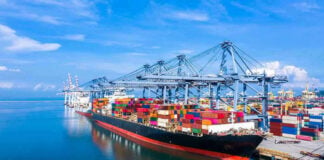 Tariffs Struck Down, Triggering Massive Refund Battle Container ship docked at a busy industrial port.