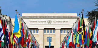 U.S.–Iran Agreement Nears, but Core Terms Still Undecided United Nations building with numerous national flags outside.