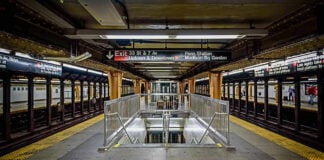 Woman Choked in Subway Hate Attack Subway station platform with directional signs overhead.