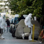 False Alarm Shuts Down Pentagon Areas Investigators in hazmat suits carrying equipment cases.