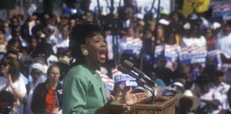 The ‘First Black President’ Debate Returns A woman passionately speaking at a political rally in front of a large crowd