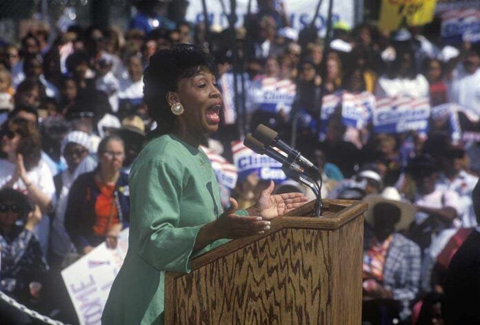 Congresswoman,Maxine,Waters,Addresses,Crowd,At,The,Maxine,Waters,Employment A woman passionately speaking at a political rally in front of a large crowd