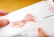 Court Won’t Block Trump Voting Order A hand holding an envelope labeled Official Election Mail