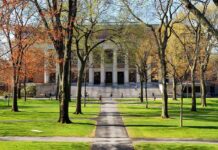 Campus Speech War Explodes at Missouri State Students walking on a university campus with autumn trees and a historic building in the background