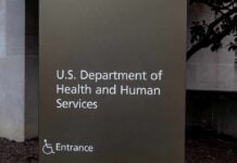 Hundreds of Thousands of Migrant Children Went Untracked Sign for the U.S. Department of Health and Human Services with an entrance indication