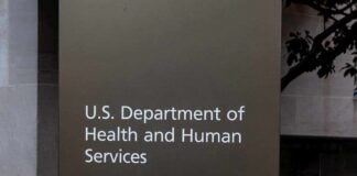 Hundreds of Thousands of Migrant Children Went Untracked Sign for the U.S. Department of Health and Human Services with an entrance indication