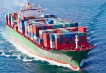 Navy Escort Plan for Oil Tankers Faces Capacity Concerns A large cargo ship loaded with colorful containers sailing on the ocean