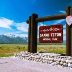 Judge Orders Restoration of National Park History Displays Entrance sign for Grand Teton National Park with mountains in the background