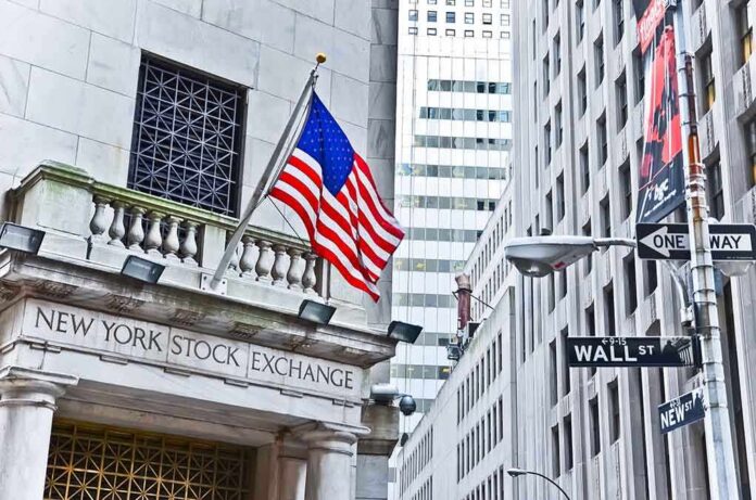 shutterstock_240002407 Facade of the New York Stock Exchange with an American flag and Wall Street sign