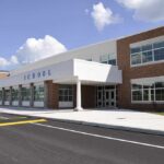 Modern school building with large windows and a clear sky