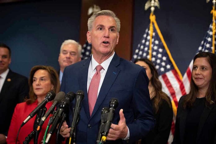 2274408301 Man speaking at a press conference with American flags.