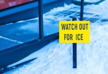 Snow Traps Tourists High in Argentina’s Andes yellow warning sign in snow near walkway